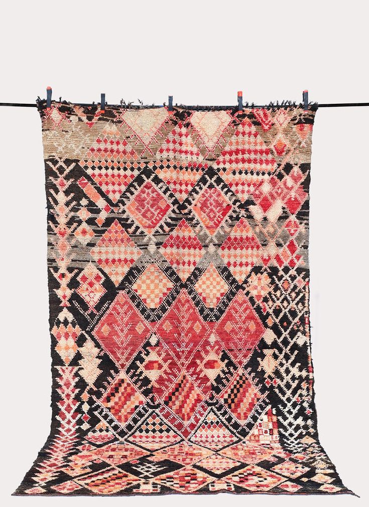 an old rug hanging on a clothesline with some clothes pins attached to it's side