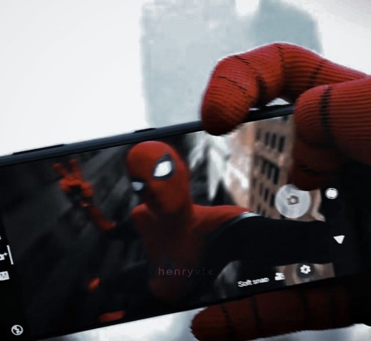 someone holding up their cell phone to take a selfie with the spider - man