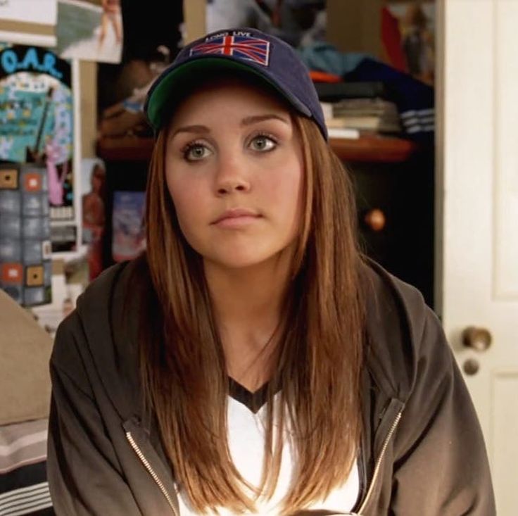 a woman with a baseball cap is looking at the camera