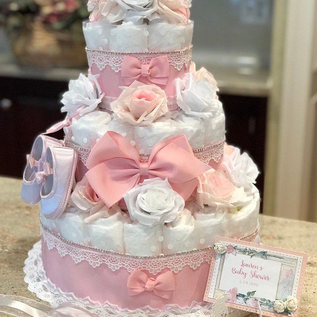 a three tiered cake with pink and white flowers