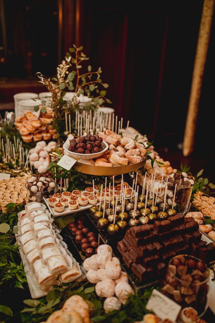 a table filled with lots of different types of desserts and candies on sticks