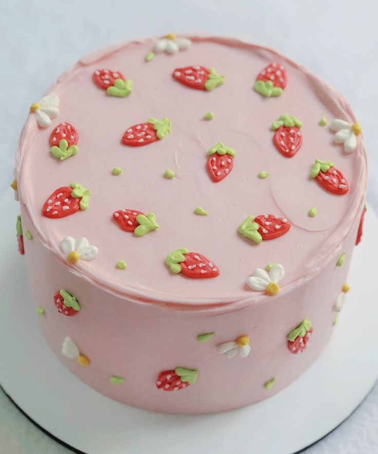 there is a pink cake with strawberries on it