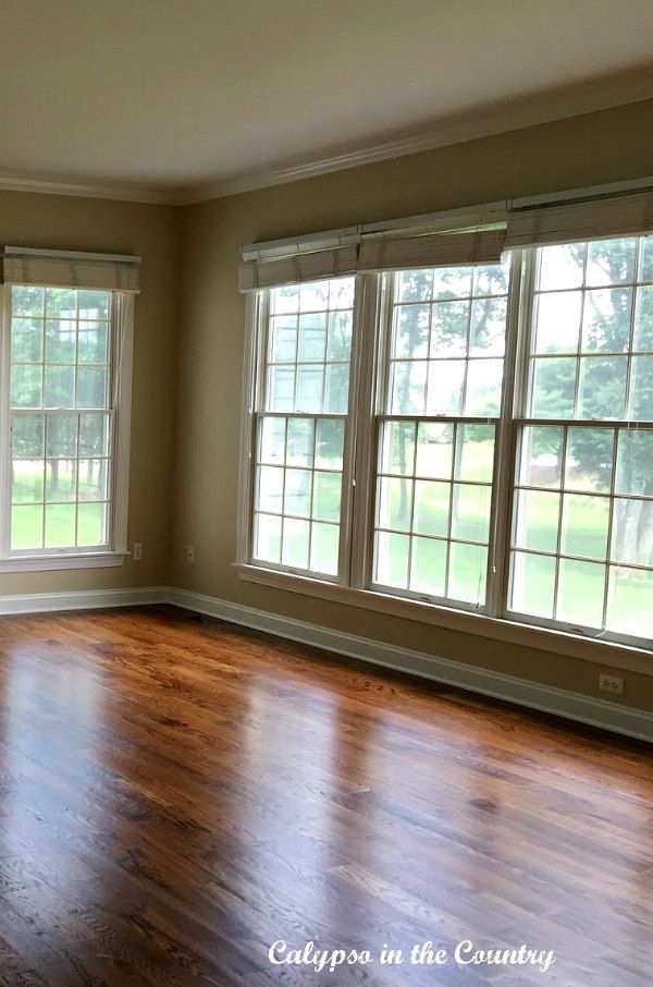 empty living room with hard wood floors and large windows