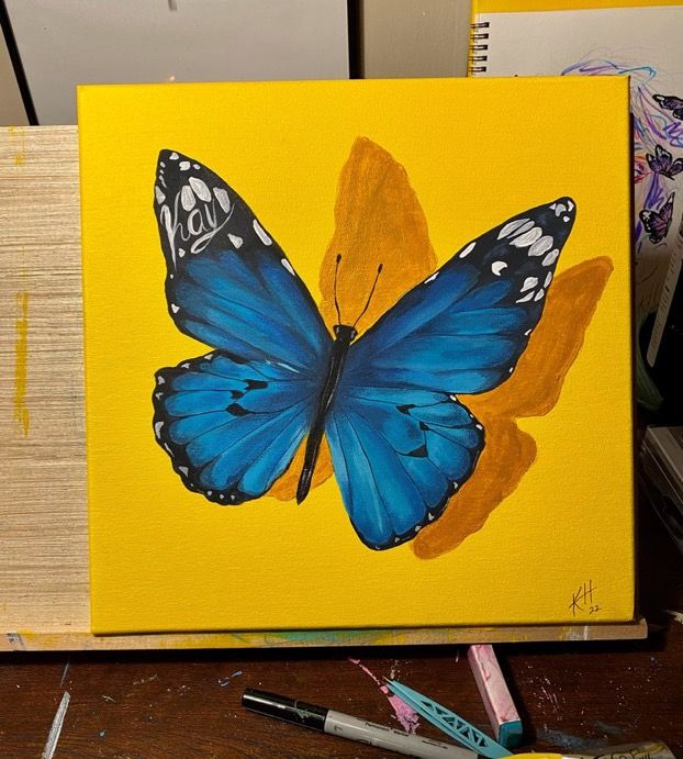 a painting of a blue butterfly on a yellow background