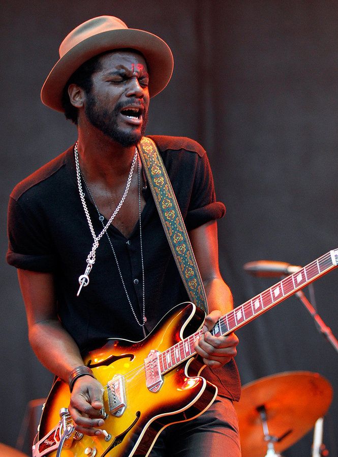 a man with a hat playing an electric guitar