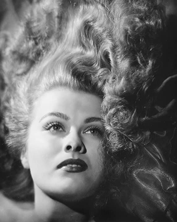 black and white photograph of a woman with curls on her head, looking off to the side