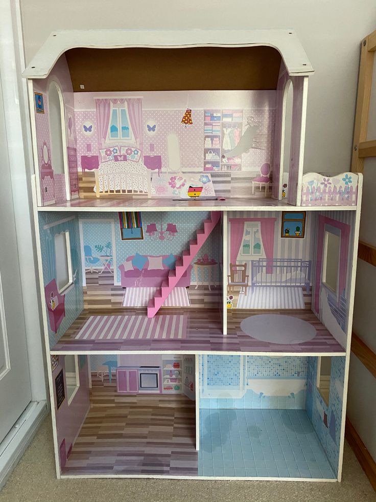 a doll house with stairs and furniture inside