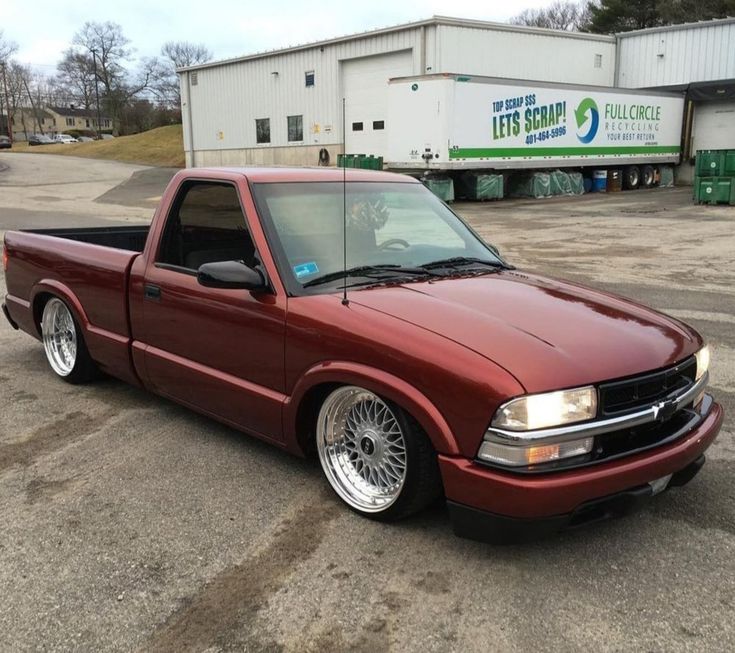 a red pick up truck parked in front of a building