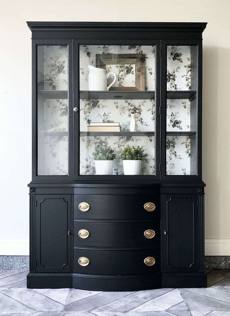 a black china cabinet with glass doors and drawers