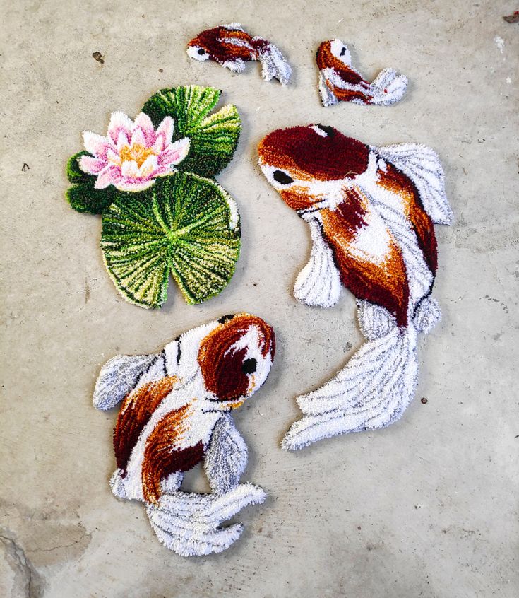 two koi fish and a flower on the ground