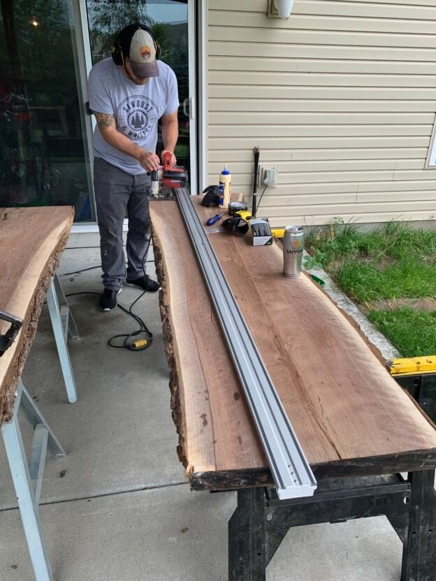 a man is working on a table made out of two large pieces of wood and metal