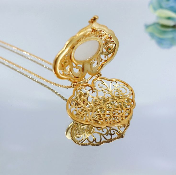 Enhance your elegance with our stunning Ruyi Locket Necklace, beautifully framed in gold-plated sterling silver and zirconia. The necklace is sized at 3x3cm, making it a perfect fit for both round and rectangular faces. The Ruyi Locket Necklace also features a premium Italian chain for a sophisticated finish.❀ Exquisite Ruyi Locket Pendant with Nephrite Hetian Jade; 3 × 3 cm (1.2 × 1.2 Inch)❀ Gold Plated Sterling Silver and Zirconia❀ Italian Premium Chain 20 Inch Exquisite Gold Jewelry With Pearl Pendant, Elegant Gold Square Pendant Jewelry, Exquisite Gold Jewelry Gift, Exquisite Gold Jewelry As Gift, Elegant Hallmarked Rectangular Pendant Jewelry, Luxury Oval Pendant Locket Necklace As Gift, Exquisite Gold Plated Necklaces As Gift, Gold Square Pendant Fine Jewelry, Elegant Gold Oval Pendant Locket Necklace