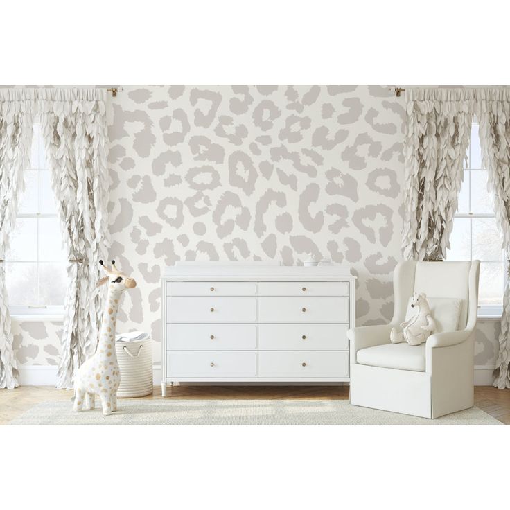 a baby's room with white furniture and leopard print wallpaper on the walls