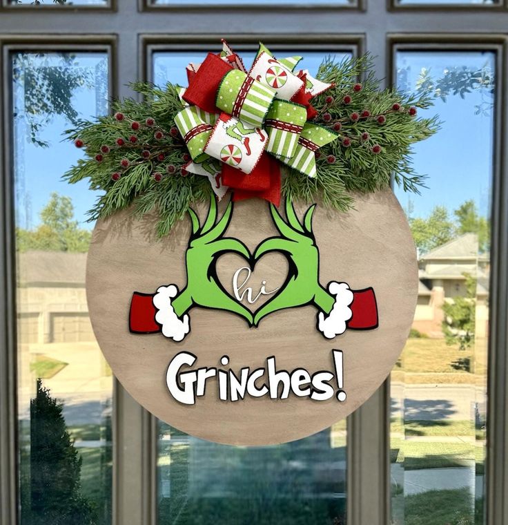 a christmas wreath with the words grinches hanging from it's front door window