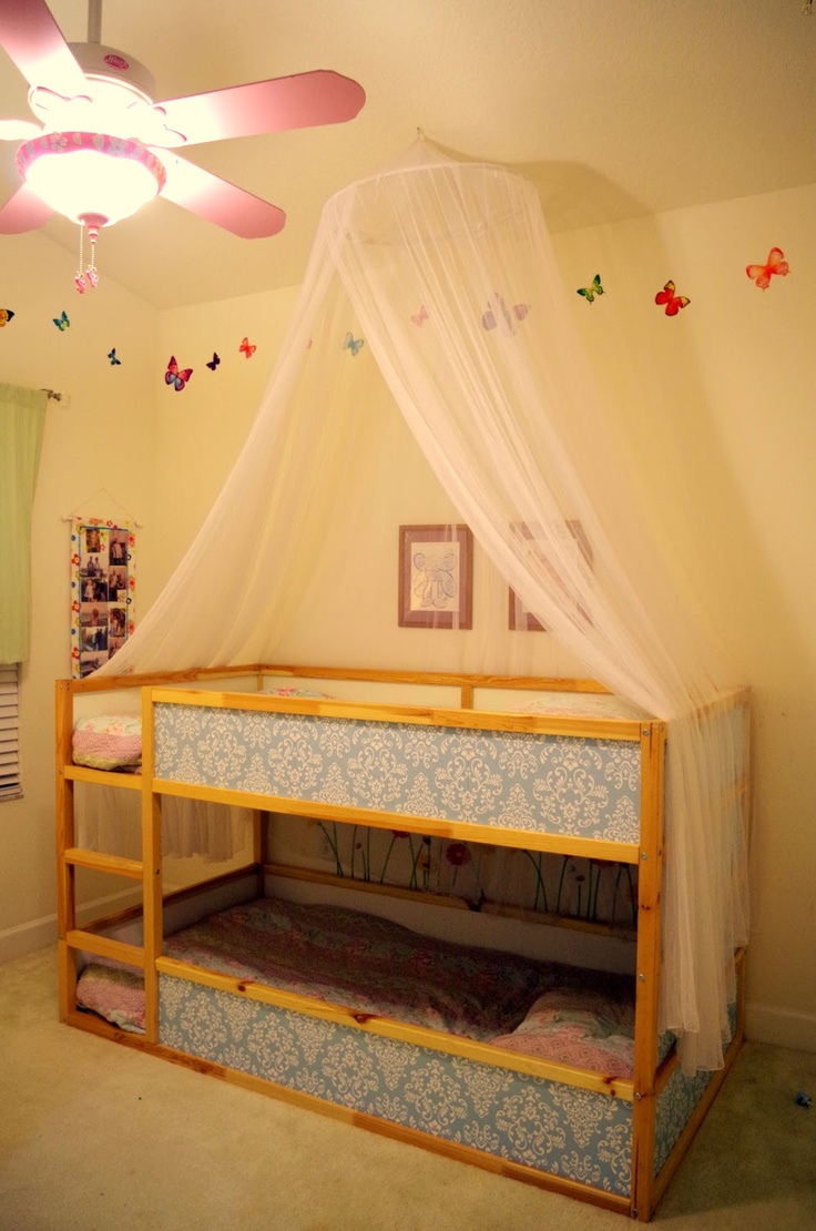 a bed with a canopy over it in a child's room or playroom