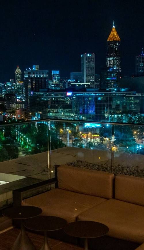 a couch sitting on top of a wooden floor next to a tall building at night