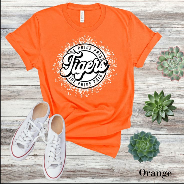 Support your team and show your Tiger pride with our "Go Tigers" T-shirt - because being a Tiger means never backing down! This classic unisex jersey short sleeve tee fits like a well-loved favorite. Soft cotton and quality print make users fall in love with it over and over again.  .: 100% Airlume combed, and ring spun cotton (fiber content may vary for different colors) .: Light fabric (4.2 oz/yd² (142 g/m .: Retail fit .: Tear away label .: Runs true to size CARE INSTRUCTIONS Wash item inside out in cold water Do not bleach Do not dry clean Do not iron directly on the design. Tumble dry low. NOTE: All apparel items from Chosen Chic are Direct to Garment printing which means the design is print into the fibers of that fabric and will last longer and be more durable than screen printing. Team Spirit T-shirt With Screen Print For Fan Gear, Team-colored T-shirt With Screen Print For Game Day, Pre-shrunk Team-colored Fan Apparel T-shirt, Team-colored T-shirt With Screen Print For Fans, Team Spirit T-shirt With Letter Print For Fans, Game Day T-shirt With Screen Print For Sports Season, Pre-shrunk Tri-blend T-shirt For College, Pre-shrunk Fan Apparel T-shirt For Game Day, Short Sleeve T-shirt For Baseball Season With School Spirit