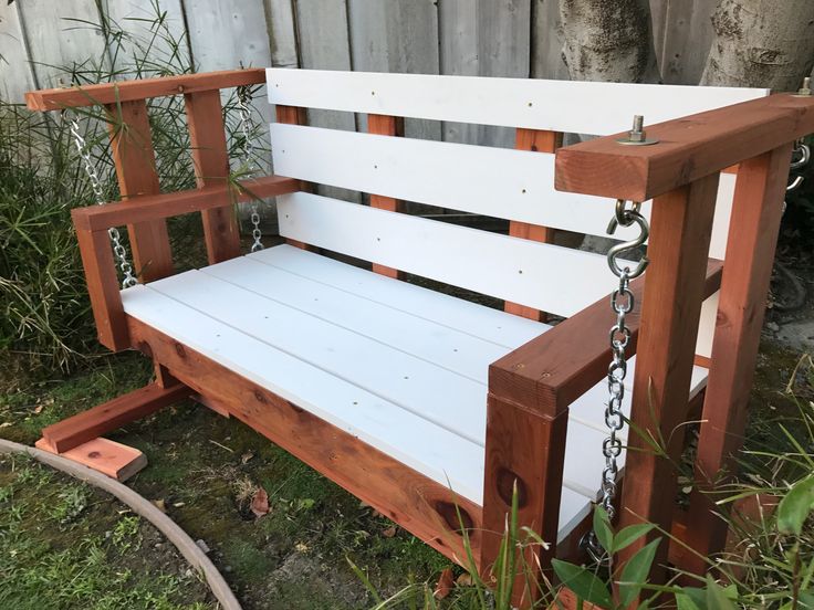 a wooden swing with chains attached to it