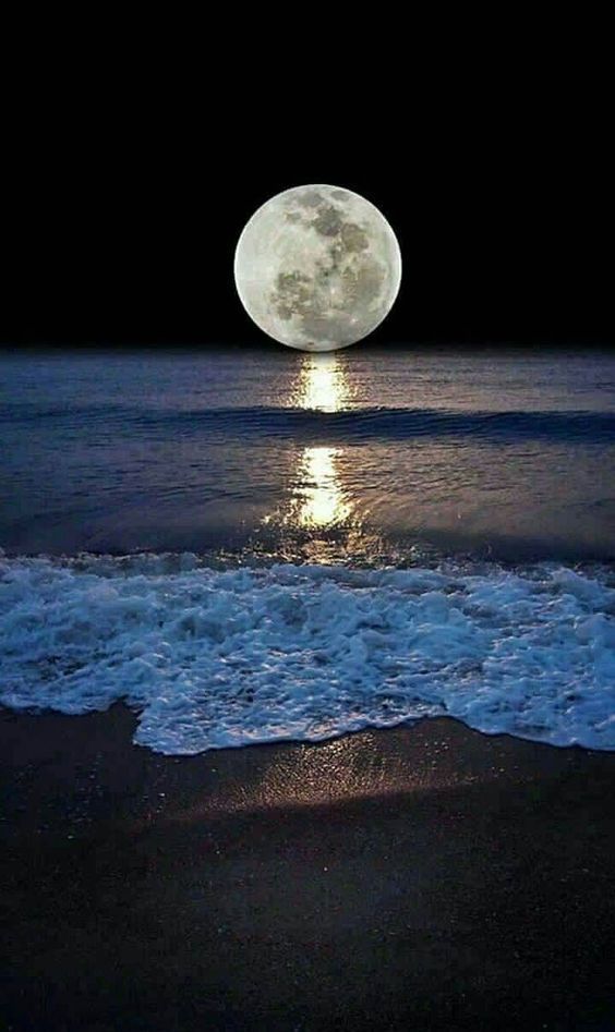 the moon is shining over the ocean with waves