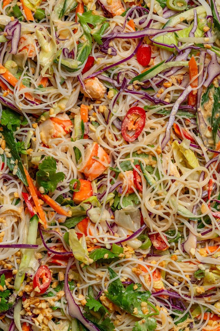 a salad with noodles, carrots and other vegetables