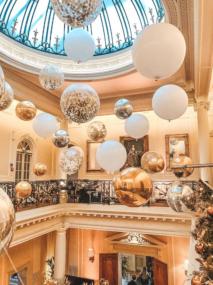 an indoor christmas tree in the middle of a building with lots of ornaments hanging from it's ceiling