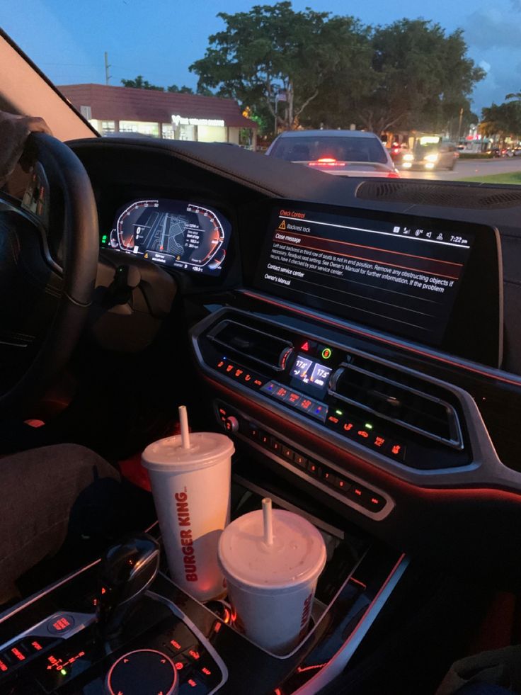 the interior of a car with drinks and snacks on the dash board in front of it