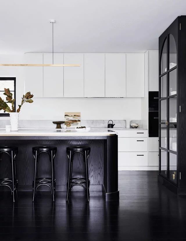 a black and white kitchen with bar stools