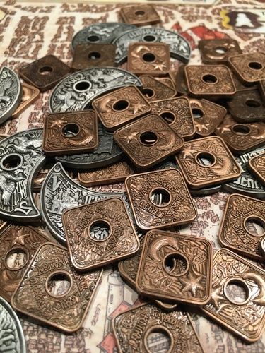 lots of bronze and silver metal buttons on top of a table with an ornate pattern