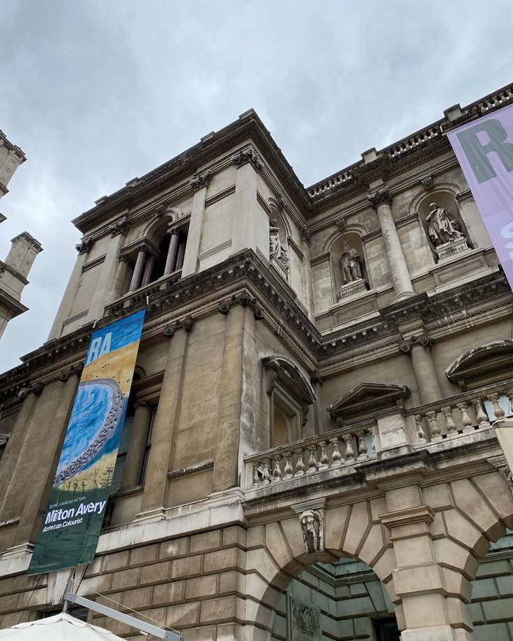 an old building with banners hanging from it's sides and on the outside wall