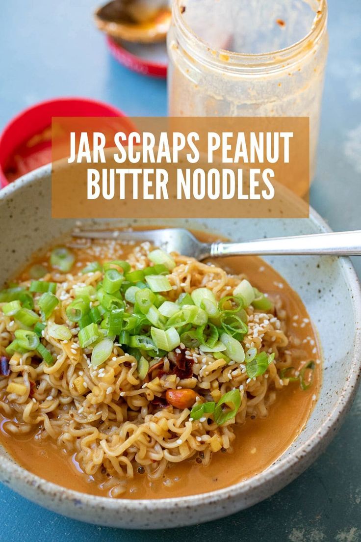 a bowl filled with noodles and vegetables next to a jar of peanut butter noodle