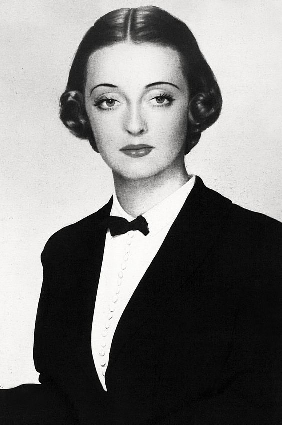 an old black and white photo of a woman in a tuxedo