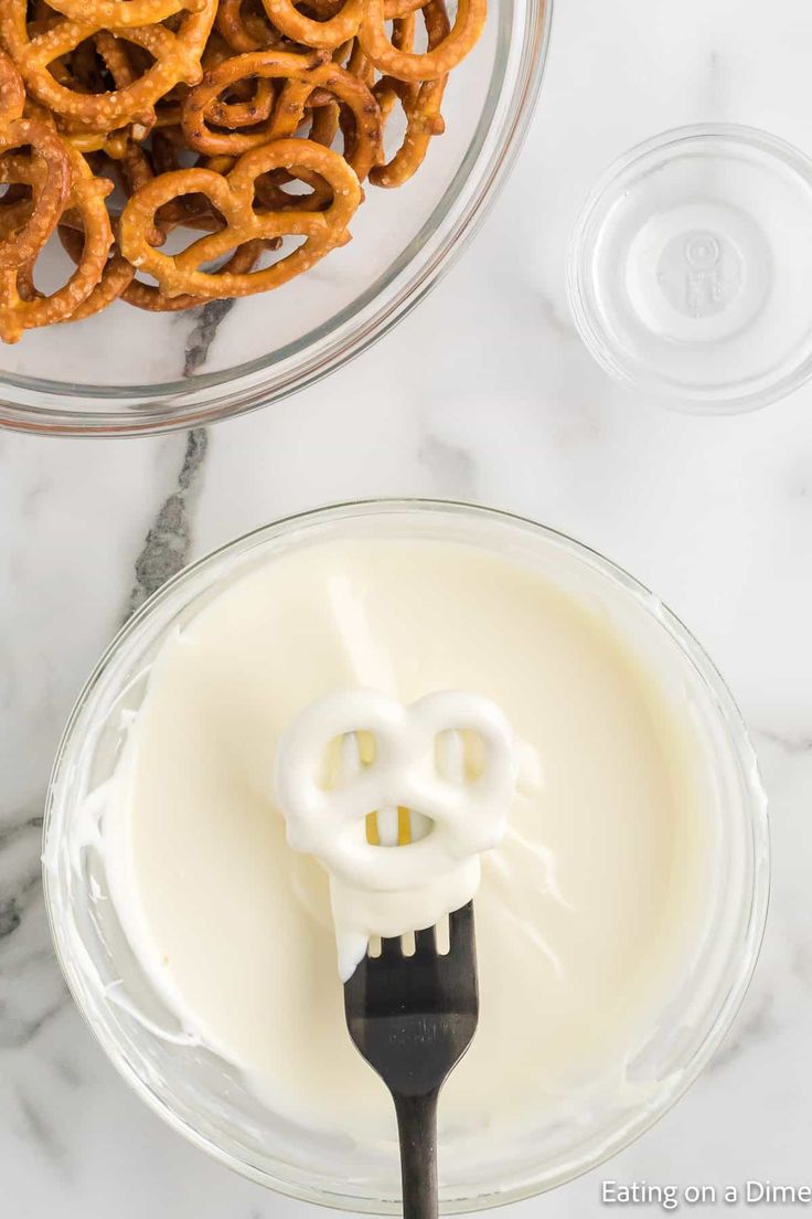 pretzels and cream in a bowl next to a spoon on a marble counter