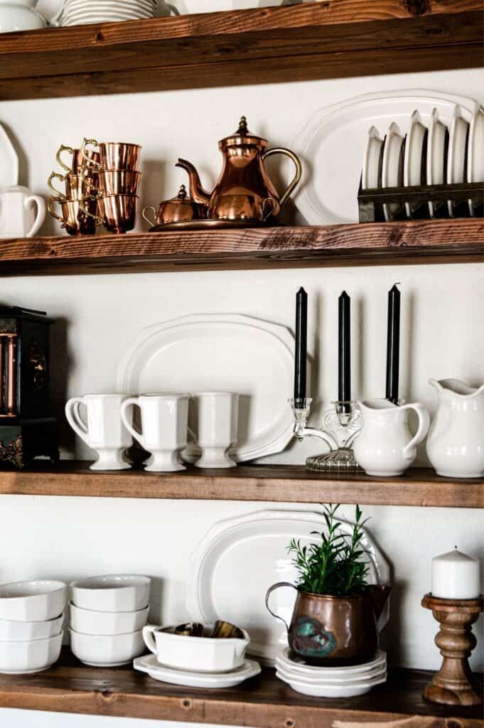 the shelves are filled with dishes and cups