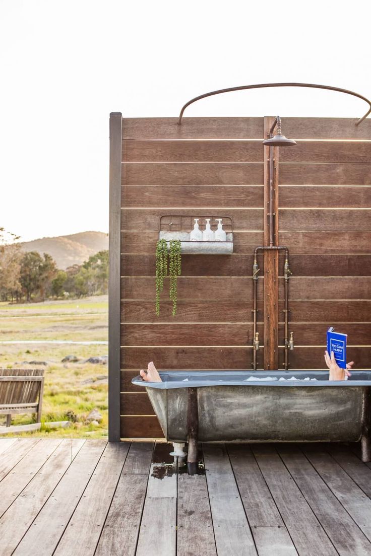 a woman taking a selfie with her cell phone in front of a bathtub