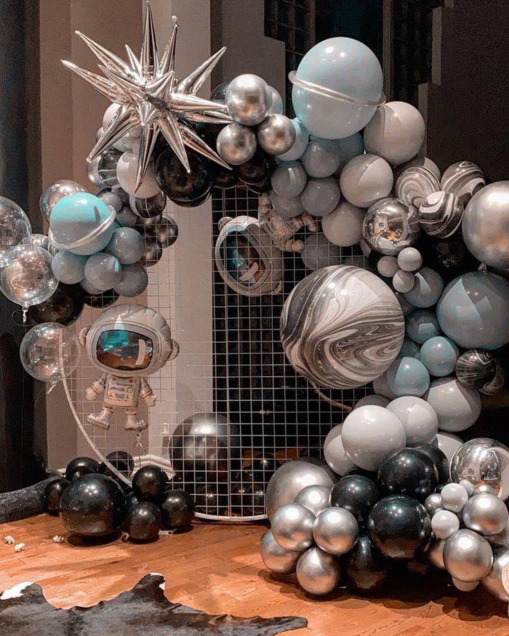 a table topped with balloons and ornaments on top of a wooden table next to a mirror