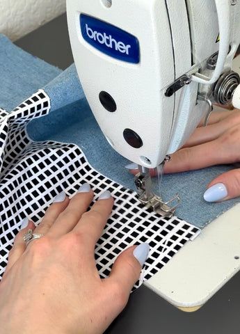 a woman is using a sewing machine to sew on some fabric with her hands