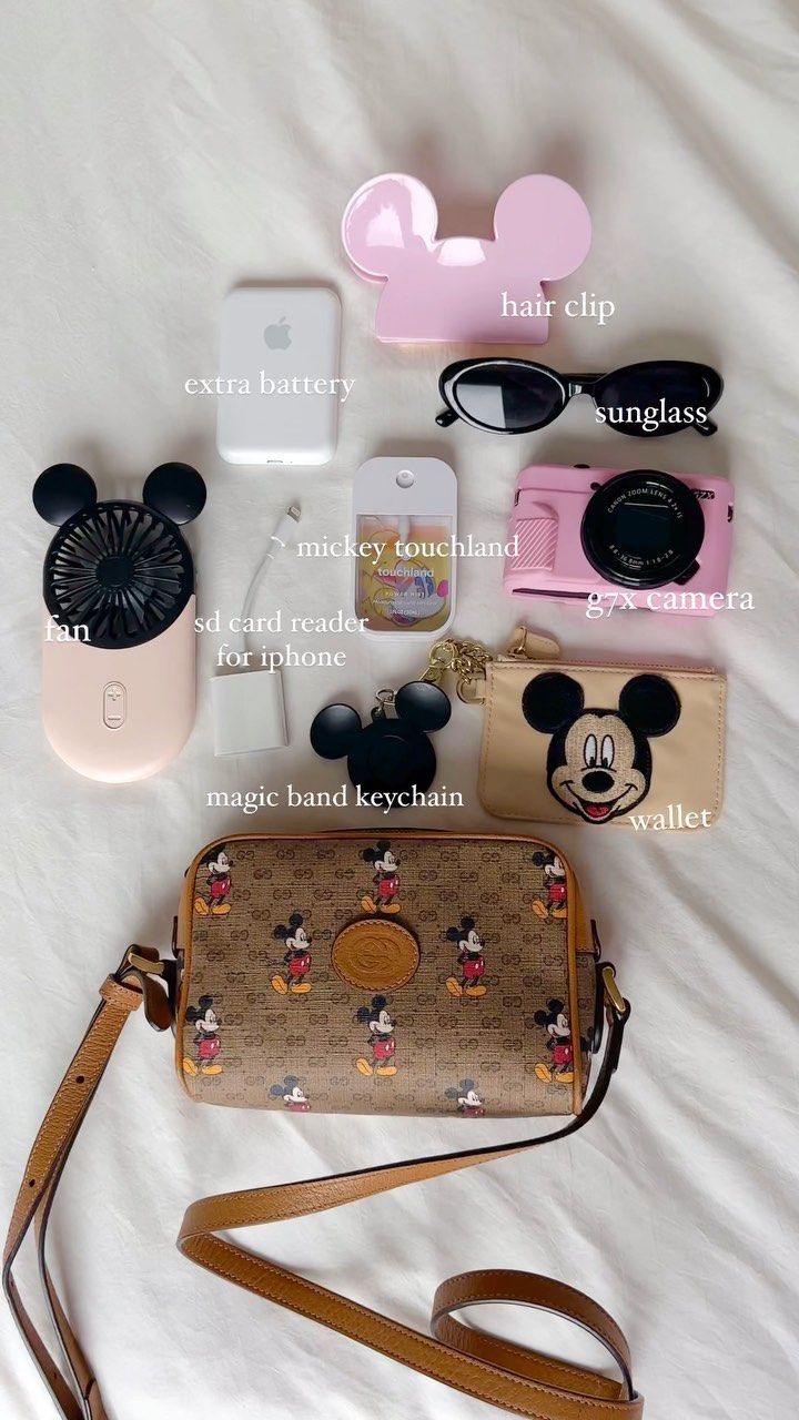 the contents of a mickey mouse purse laid out on a bed