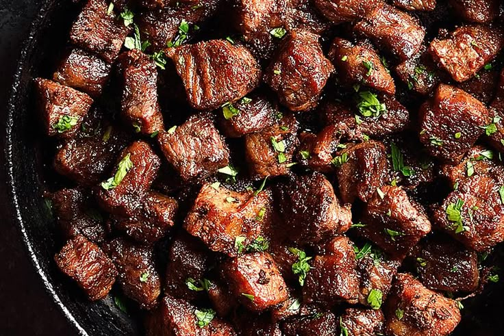 meat in a skillet with parsley on top