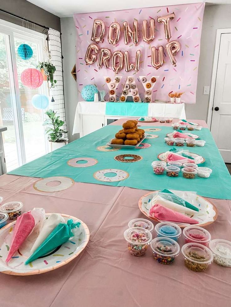 a table topped with donuts and cupcakes next to a sign that says donut grow up