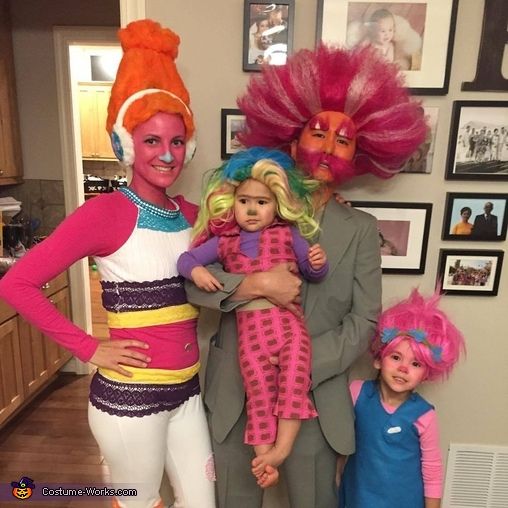 three people dressed up in costumes posing for a photo with two children and one adult