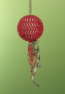 a red ball hanging from a string on a green wall