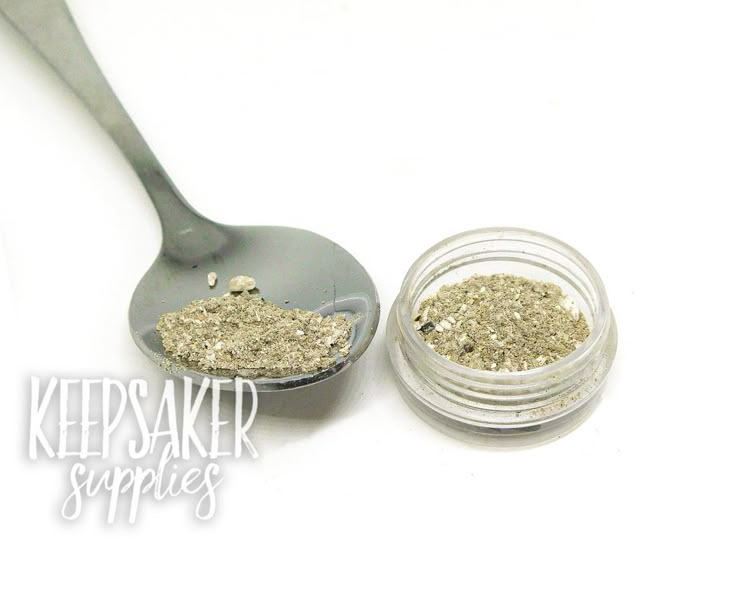 a spoon with some glitter on it next to a jar of gold flecks