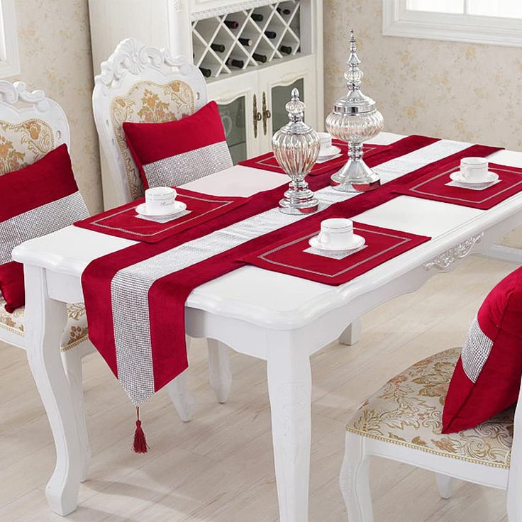 a dining room table with red and white striped cloth on the chair covers, along with matching chairs