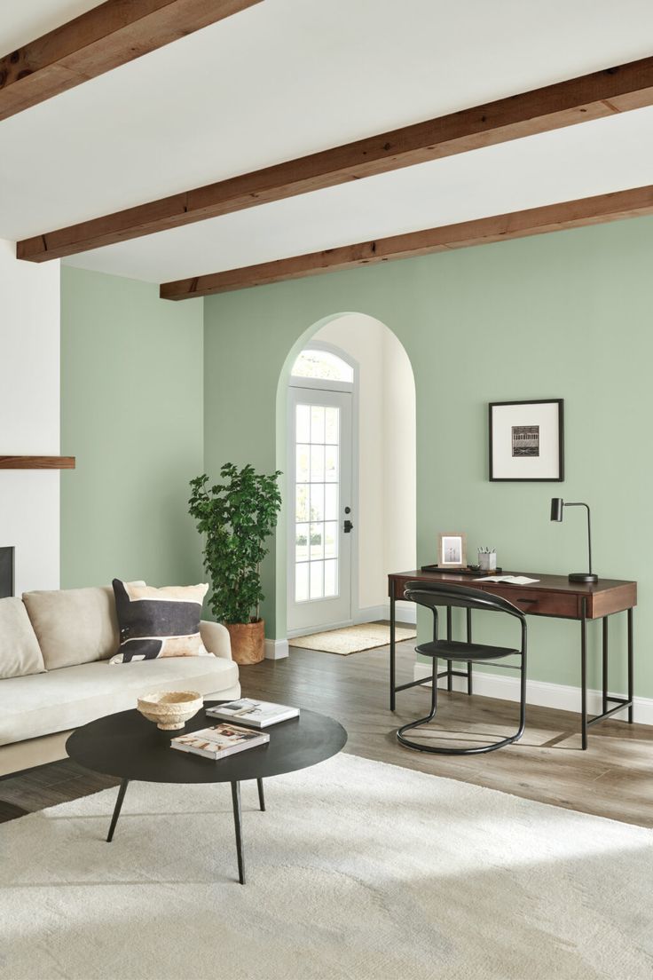 a living room with green walls and white furniture