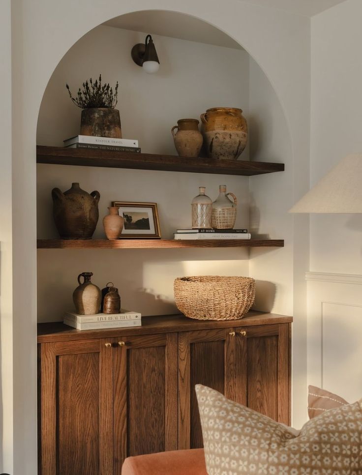 a living room filled with furniture and shelves covered in vases on top of them