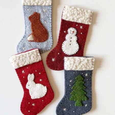 three christmas stockings with animals and trees on them