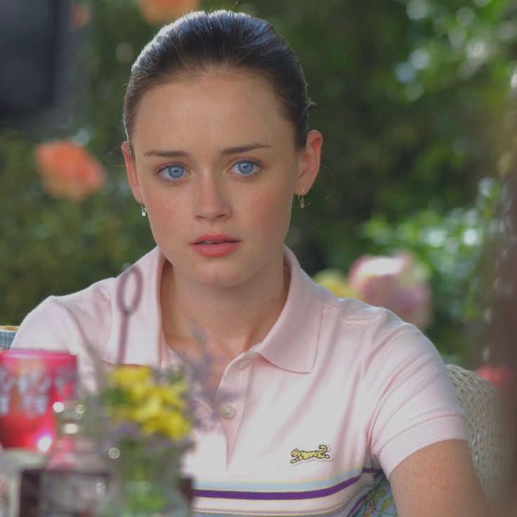 a woman with blue eyes sitting at a table