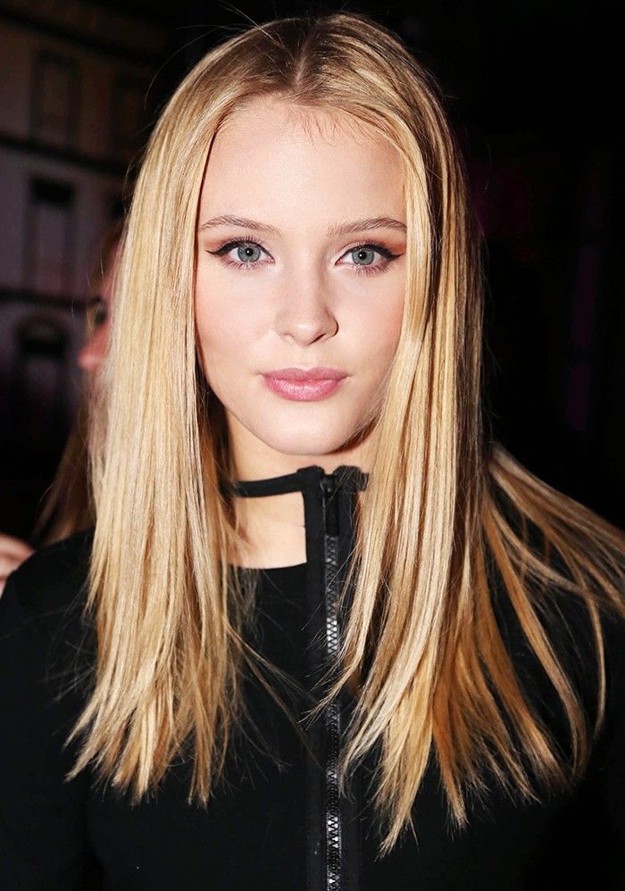 a woman with long blonde hair wearing a black top