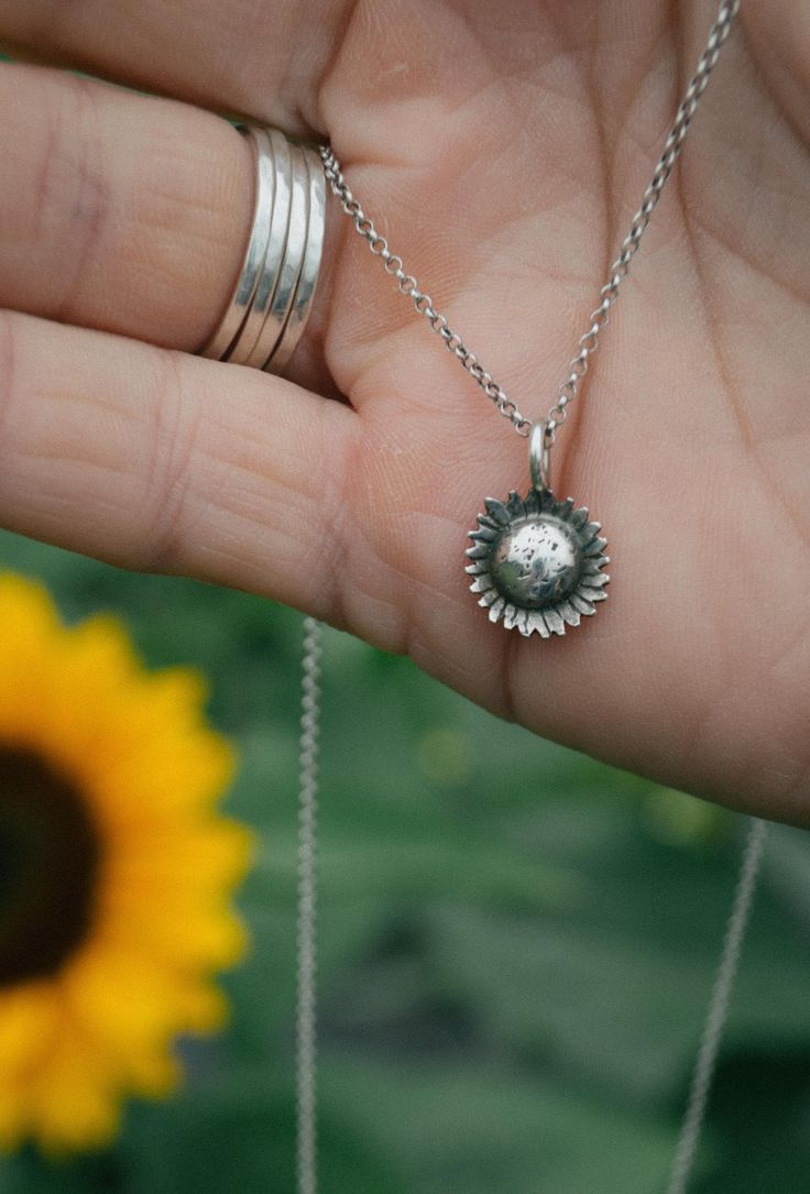 This dainty sunflower charm is hand-sawn from sterling silver, hand stamped and formed to resemble the cutest of summer flowers. It is strung on your choice of a 16" or 18" sterling silver rolo chain. This necklace pairs perfectly with my sunflower earrings. The essential summer jewelry for the flower lover.  This item is made to order. Please allow up to three weeks turn around time. Please ask any and all questions before purchasing. This item is handmade, there may be slight variations or imperfections. Silver Flower Jewelry For Everyday Wear, Everyday Flower Charm Jewelry, Handmade Dainty Sterling Silver Charm Necklace, Everyday Jewelry With Flower Charm Round Pendant, Everyday Jewelry With Round Flower Charm Pendant, Dainty Flower Jewelry For Everyday, Dainty Sterling Silver Flower Jewelry, Nickel Free Flower Pendant Charm Necklaces For Everyday, Dainty Everyday Flower Jewelry