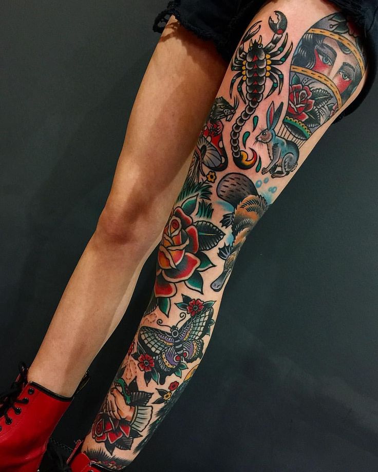 a woman's legs with tattoos and red shoes